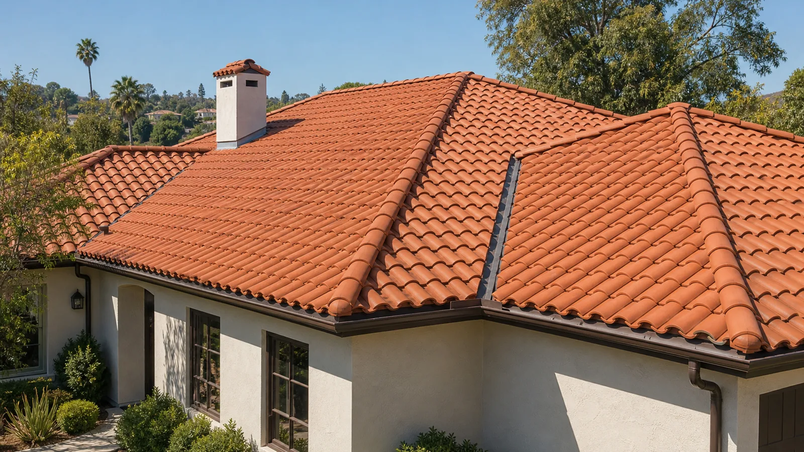 Terracotta tile roof with capped hips, ridge, open valley and gutters