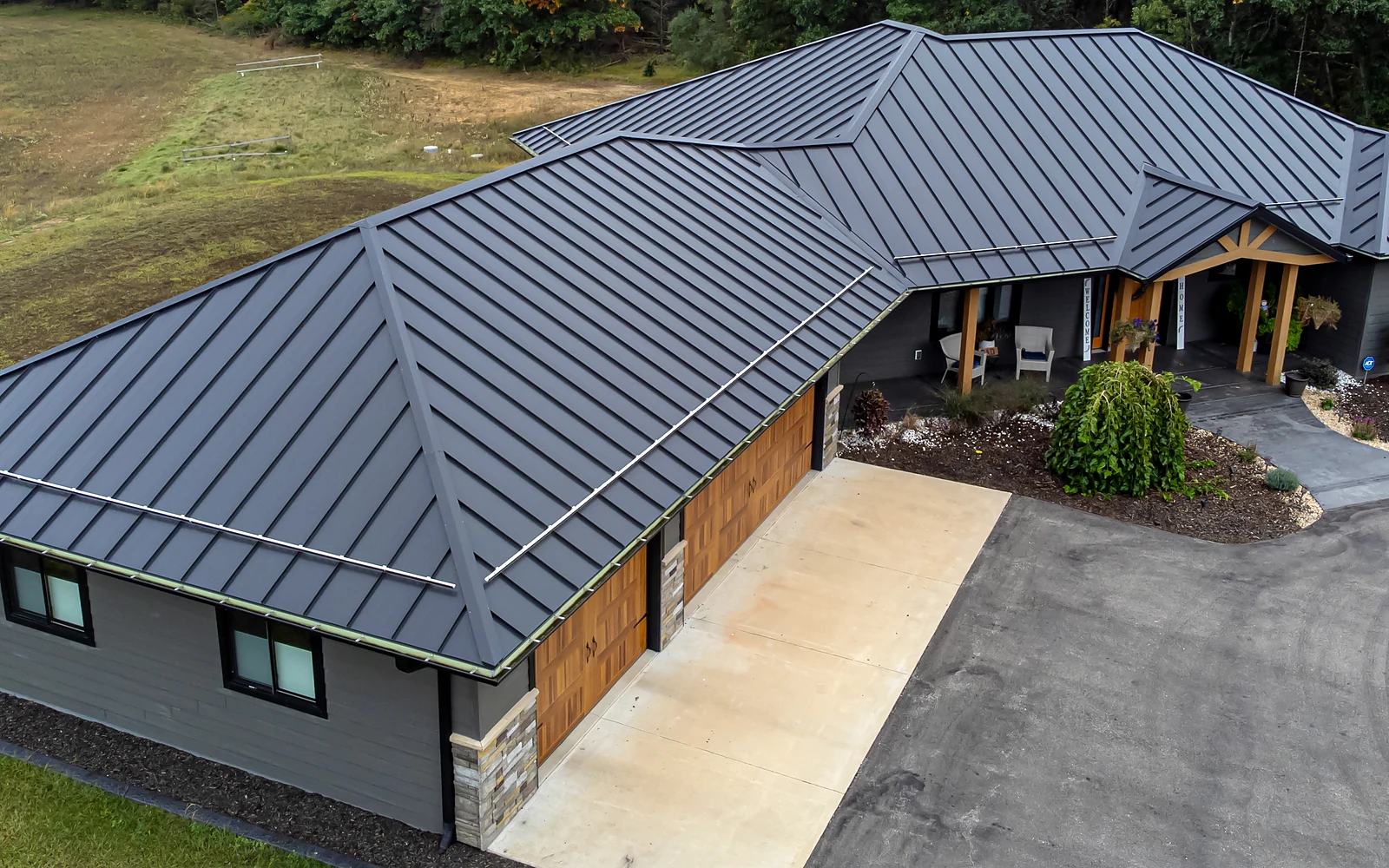 Real standing-seam metal roof showing continuous panels, hips, ridges and valleys