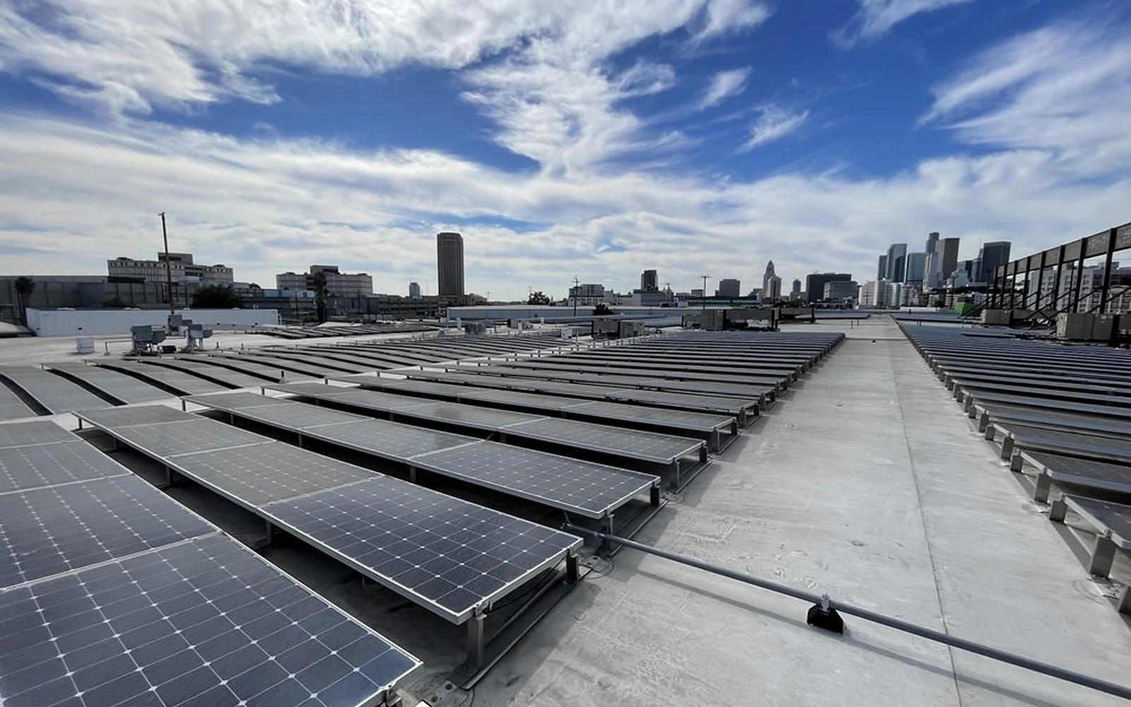 Commercial low-slope roof with solar arrays during a Sky Shield Roofing inspection in Los Angeles