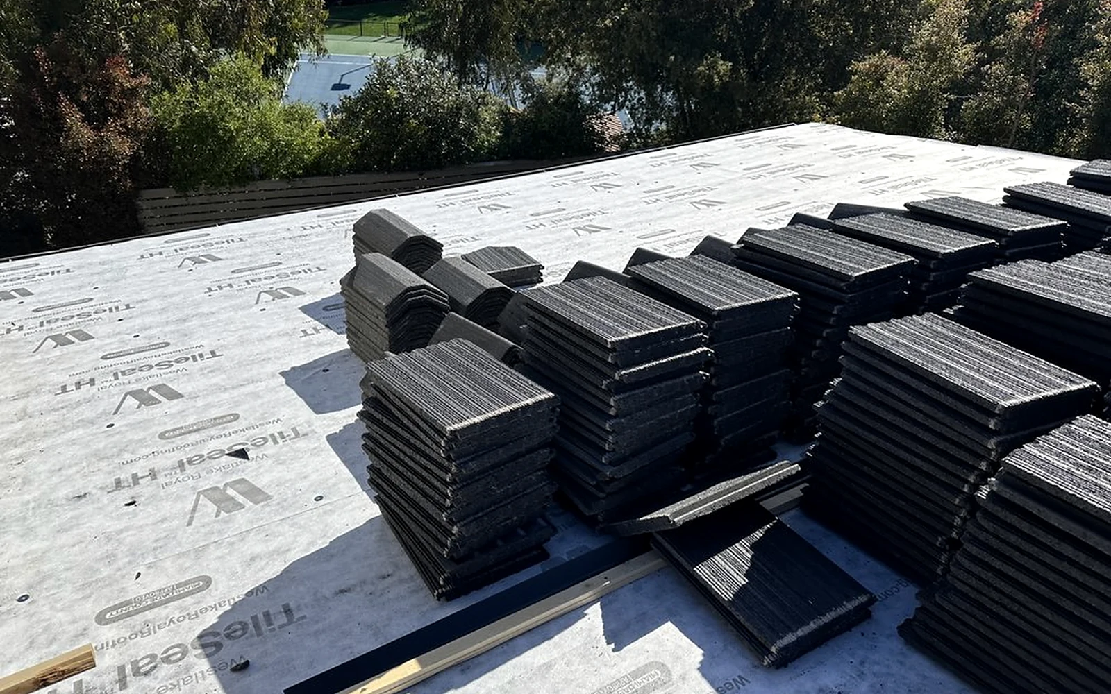Tile stacks staged over high-performance underlayment during a documented Studio City installation